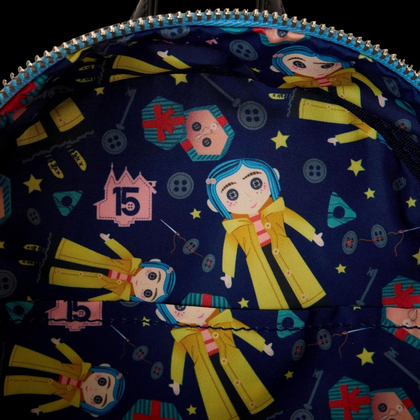 Cards & Comics Connection Coraline 15th Anniversary mini backpack interior lining with blue pattern and Coraline doll