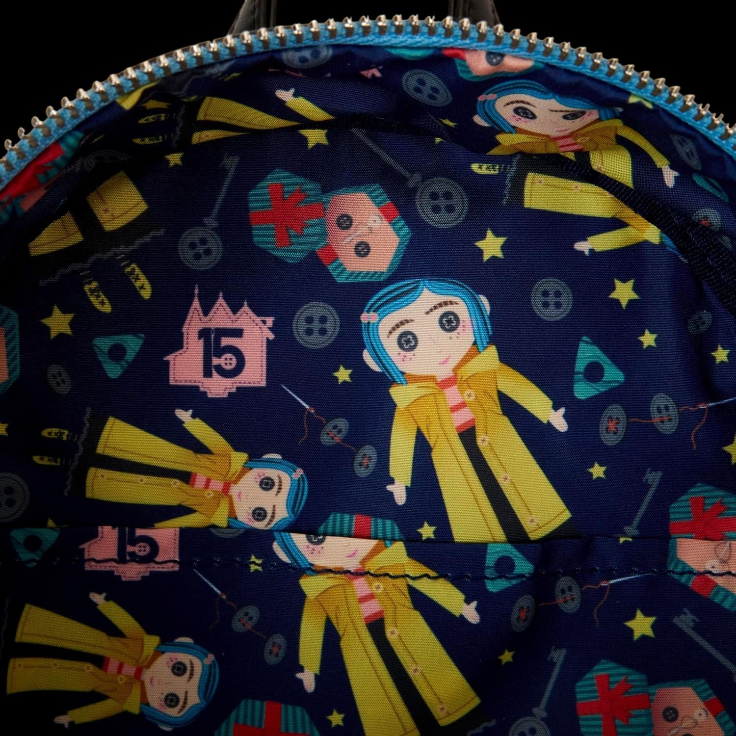 Cards & Comics Connection Coraline 15th Anniversary mini backpack interior lining with blue pattern and Coraline doll