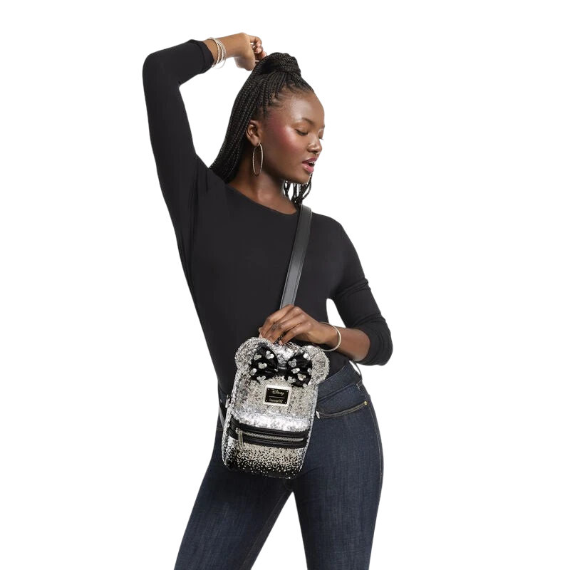 Cards & Comics Connection Minnie Mouse ombre sequin sling crossbody bag with 3D ears and a velvet bow on a model.